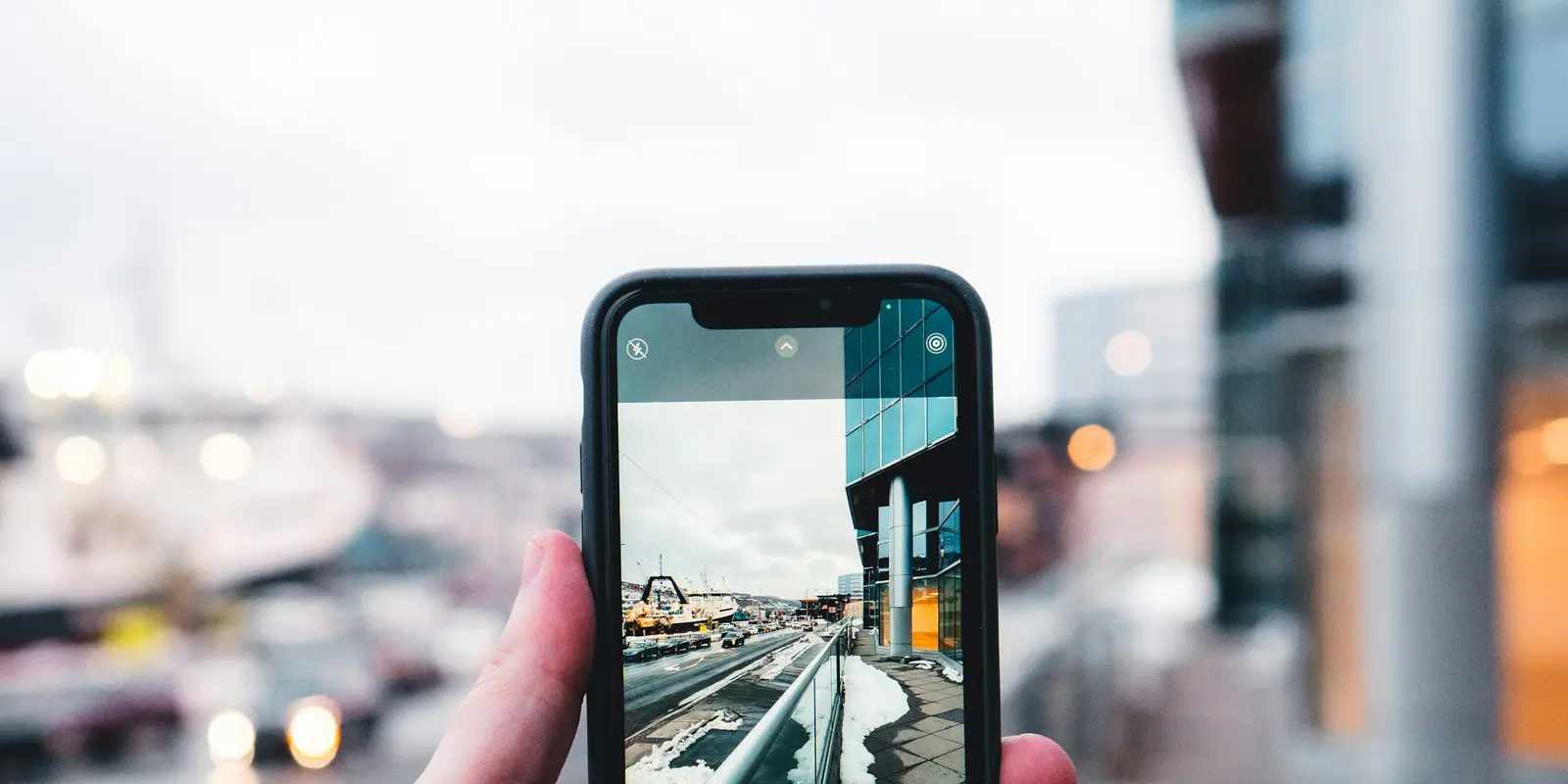 Installing before departure means the eSIM is already live when you land Person photographing a European street scene while checking their phone