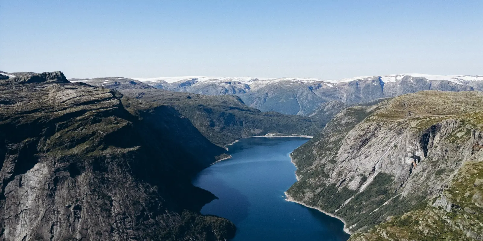 Norway's fjord country — mobile coverage here depends heavily on which of the two nationwide networks you're on Deep blue fjord surrounded by steep, snow-dusted mountains near Odda, Norway
