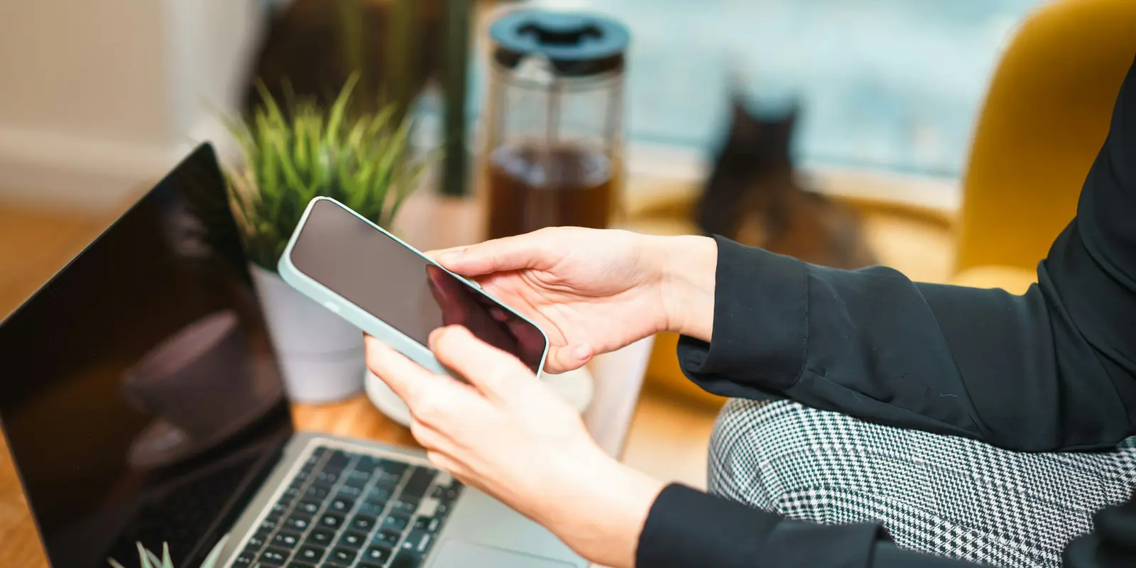 Reisender nutzt sein Smartphone als mobilen Hotspot, um einen Laptop auf einem Tisch zu verbinden