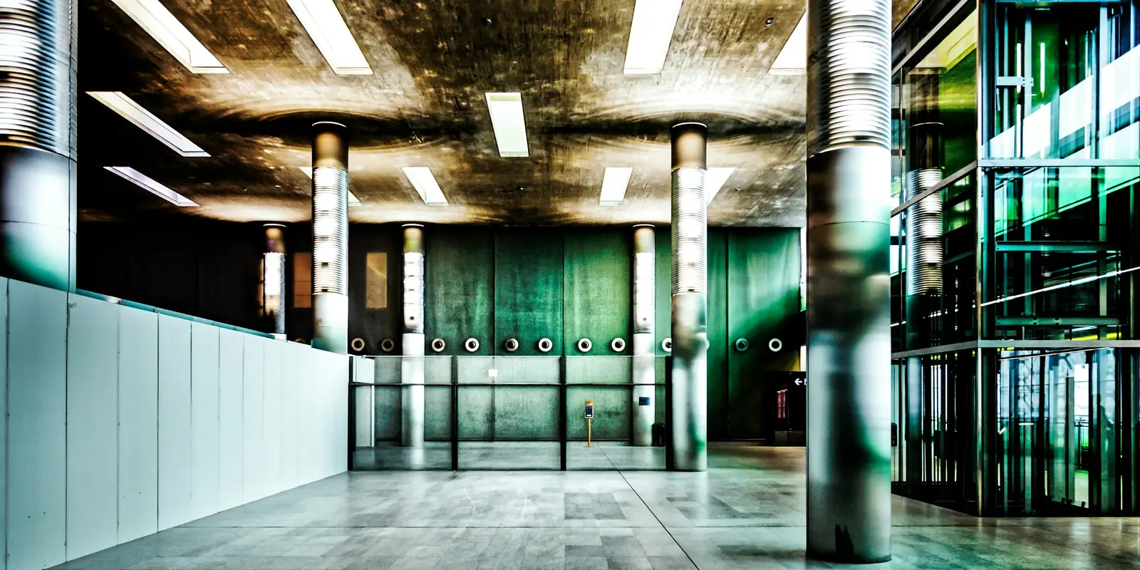Empty terminal interior with rows of columns and overhead lighting at Charles de Gaulle Airport