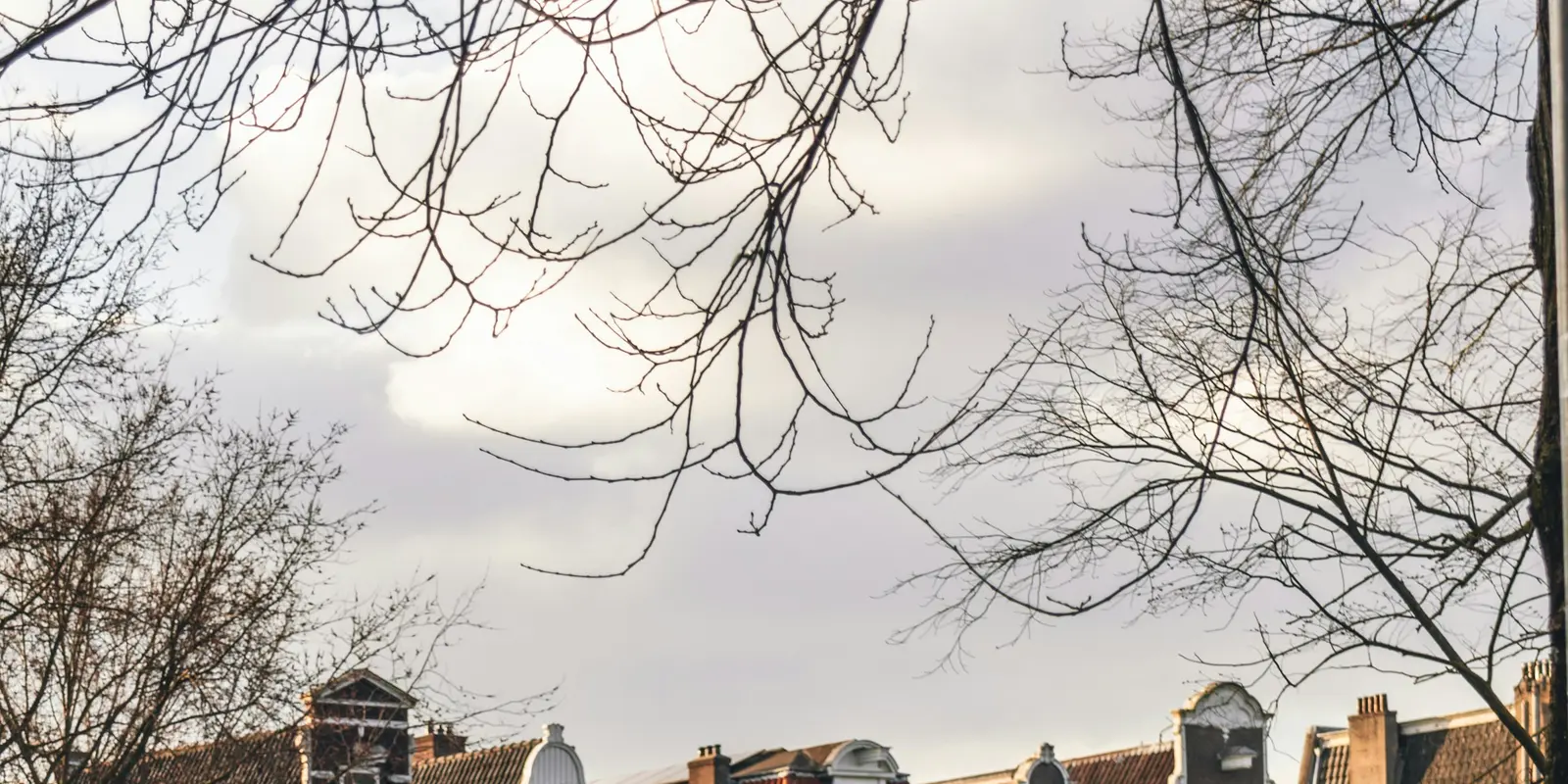 Fahrräder an einer Amsterdamer Gracht angeschlossen, typisches Bild für einen kurzen Städtetrip