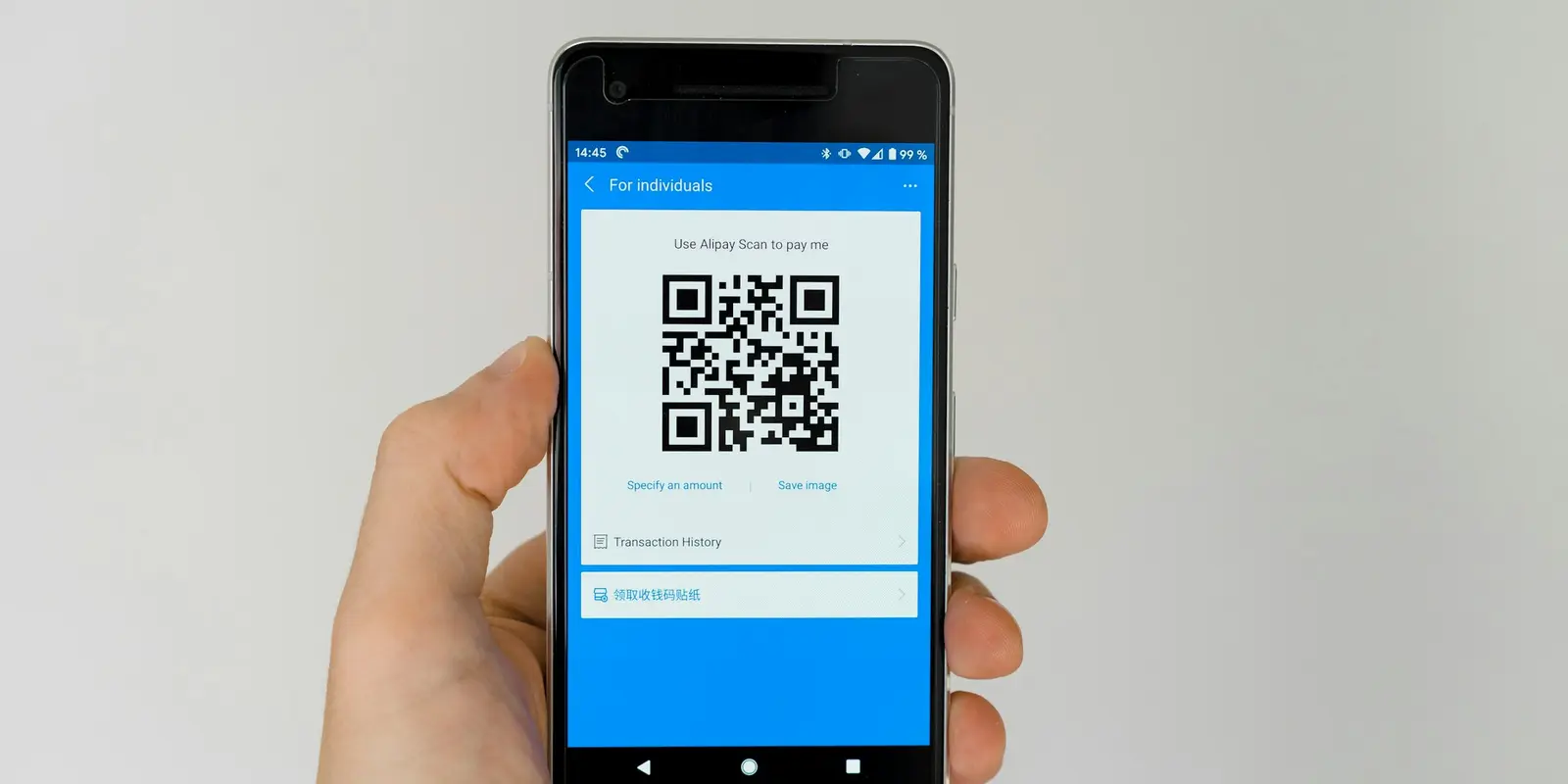 Adding an eSIM starts in the Galaxy Settings app Close-up of a hand holding a Samsung Galaxy phone with a settings menu open on screen