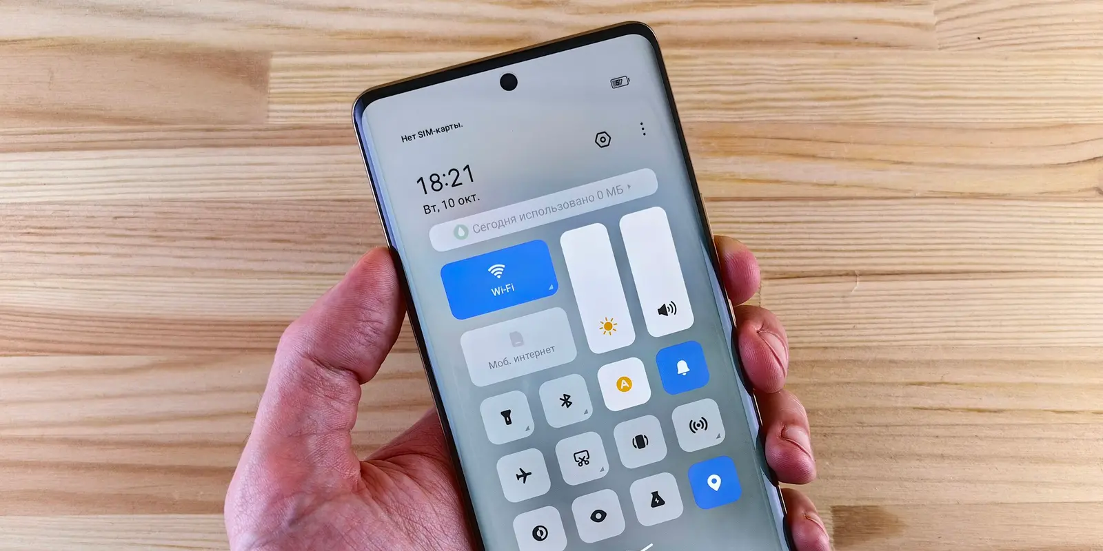 Primer plano de una mano sosteniendo un teléfono con la pantalla de ajustes abierta