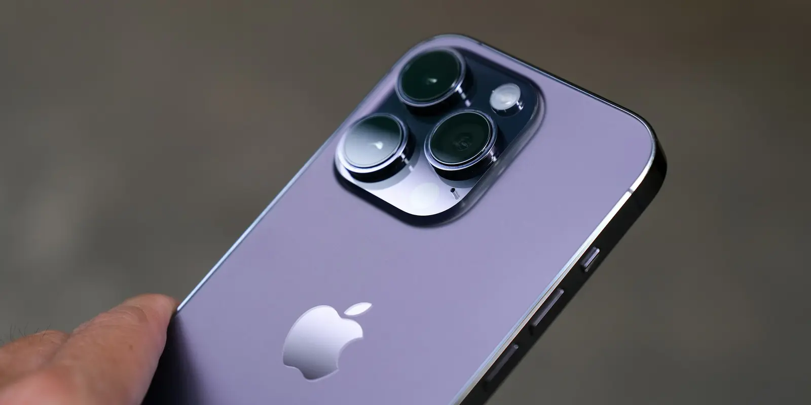 The five-minute path: Settings → Cellular → Add eSIM → scan the QR code from your delivery email Close-up of a person holding an iPhone, ready to install an eSIM