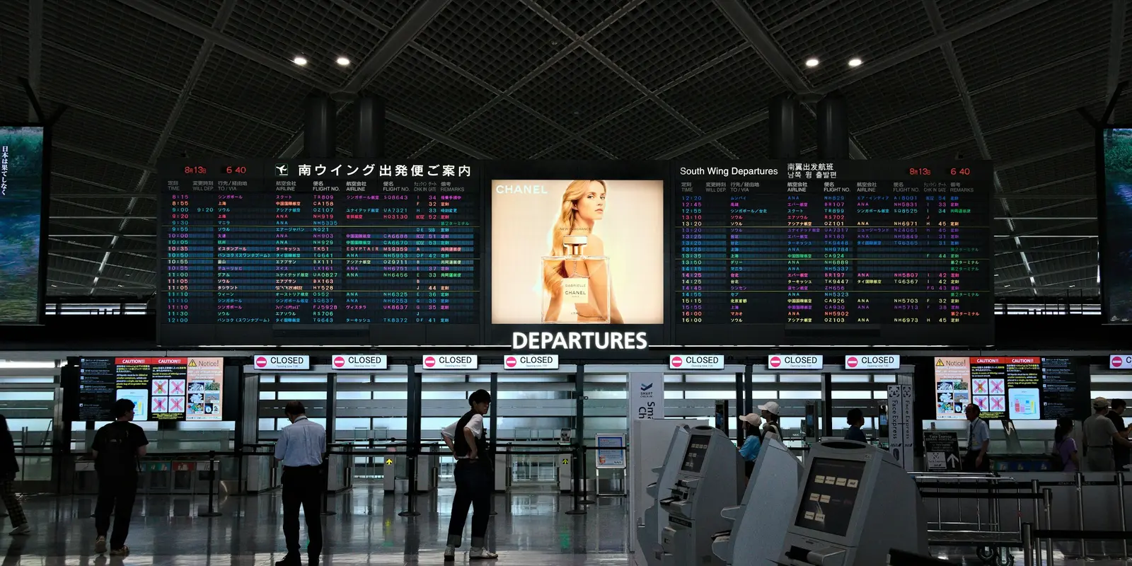 Departure terminal at Narita Airport with electronic flight information screens